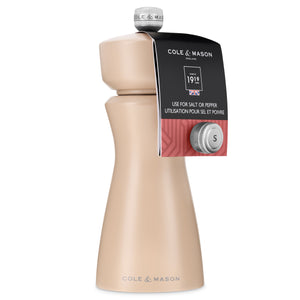 The Kenton Salt & Pepper Mill in Himalayan Salt by Cole & Mason features a modern beige design with a durable ceramic grinder for long-lasting use. It has a silver knob marked with an "S" and a tag indicating it's suitable for both salt and pepper—including Himalayan salt, with the Cole & Mason brand name printed at the base.