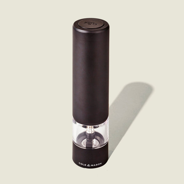 The Cole & Mason Brixton Electric Mill Matt Black GS is a black electric salt or pepper grinder featuring a clear middle section that reveals the ceramic grinding mechanism inside. Designed for convenient one-handed operation, it has the Cole & Mason brand printed at the base.