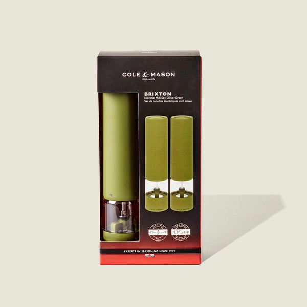 Cole & Mason Brixton Electric Mill Olive Green GS set, displayed in packaging with two mills visible through a front clear window. Designed for easy one-handed operation and equipped with robust ceramic grinders, the box features black and red accents along with white text.