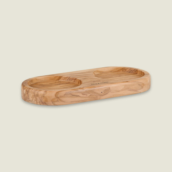 The Cole & Mason Portobello Olive Wood Mill Tray features rounded edges and two circular indentations, making it a stylish salt and pepper mill tray or elegant kitchen organizer. Its smooth, natural grain looks great on any countertop.