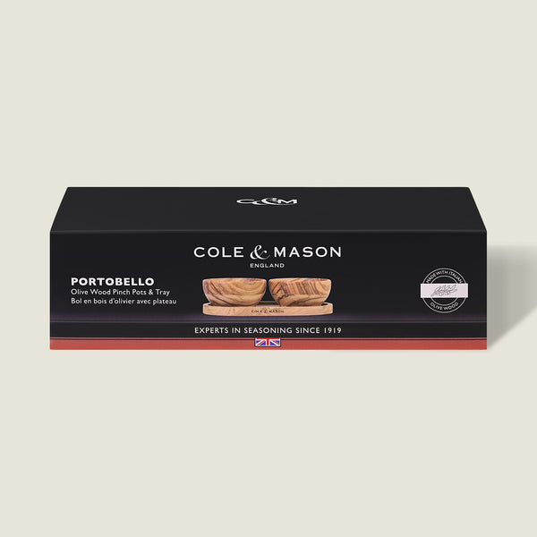 Black rectangular Cole & Mason box labeled Portobello Olive Wood Pinch Pot Set, showing unique grain olive wood pots with a seasoning tray, product image on front, and the text "Experts in Seasoning Since 1919.