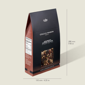 The Cole & Mason Gourmet Pepper Box, a black and brown 5.3 oz package with a clear window displaying peppercorns, stands upright at 188 mm (7.40 in) tall and 110 mm (4.33 in) wide for consistent gourmet grinding.