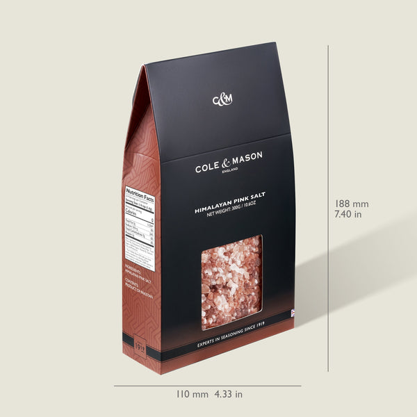 A 500g Cole & Mason Pink Himalayan Salt Box with a clear window showing salt crystals, white labeling, and nutrition facts on the side. Ideal for refilling salt mills. Dimensions: 188mm x 110mm (7.40in x 4.33in).