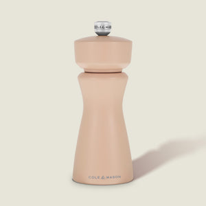 A Cole & Mason Kenton Salt & Pepper Mill in Himalayan Salt, featuring a modern, curved design with a metal knob on top and a durable ceramic grinding mechanism, is set against a plain, light background.