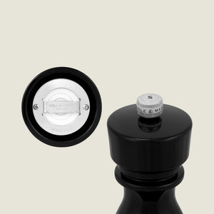 A close-up of the Cole & Mason London Black Acrylic Salt & Pepper Mill 150mm shows a silver S-marked knob and white ceramic grinding mechanism with premium technology and Cole & Mason branding.