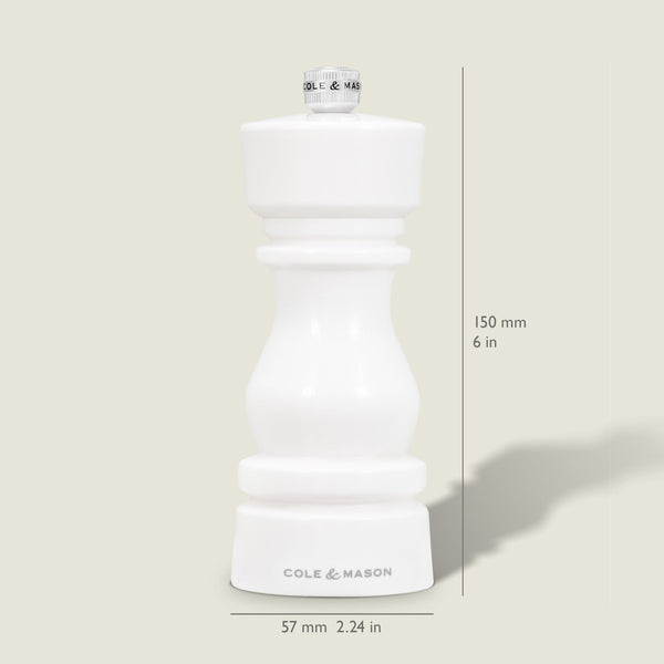 The Cole & Mason London White Acrylic Salt & Pepper Mill, measuring 150mm (6 in) tall and 57mm (2.24 in) wide, features an adjustable grinder—perfect for modern kitchens. Pictured upright on a light beige background.