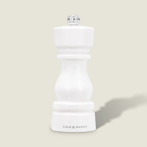 The Cole & Mason London White Acrylic Salt & Pepper Mill (150mm) with adjustable grind stands upright on a light beige background—an elegant, modern addition to any kitchen.