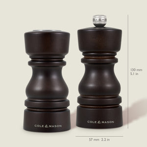 The Cole & Mason London Chocolate Wood Salt Shaker & Pepper Mill Set features two dark wooden mills, each 130 mm tall and 57 mm wide, with a premium grinding mechanism for enhanced performance.