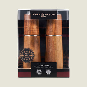 The Cole & Mason UK Marlow Natural Acacia Salt & Pepper Mills boxed set features a clear window showcasing the mills’ wood finish and branding, plus an adjustable grinder for precise seasoning.
