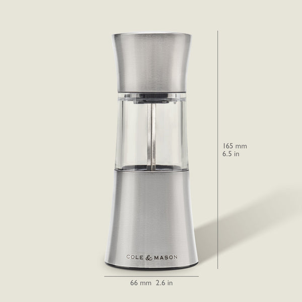 The Cole & Mason Stadhampton Chilli & Spice Mill, made of stainless steel and clear acrylic, stands upright with an ergonomic design, measuring 165 mm high and 66 mm wide. It is shown against a light background.